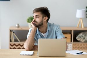 Trabajador desmotivado mira hacia la nada desilusionado por su trabajo
